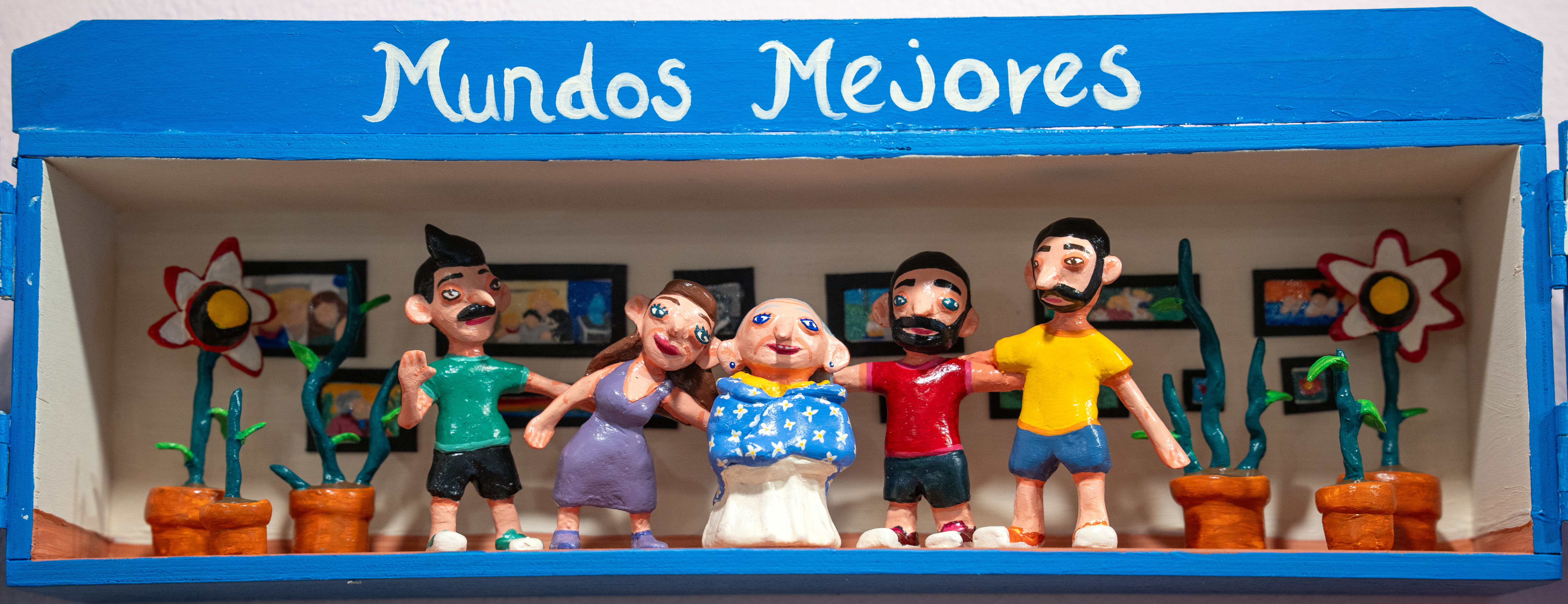 The “Mundos Mejores” box: a family of figures standing arm in arm beneath the project's title
