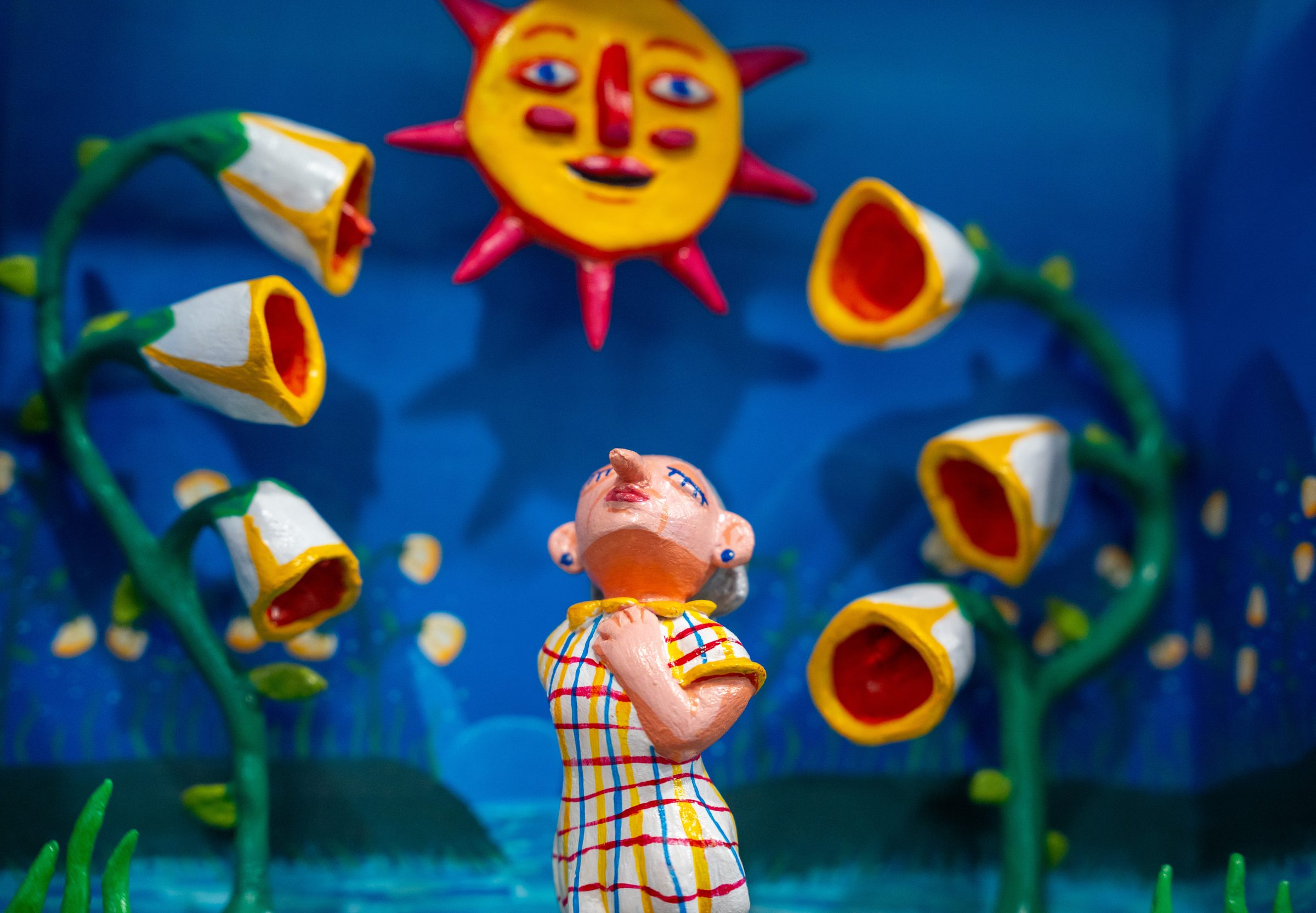 A figure basking beneath a smiling sun and blooming flowers